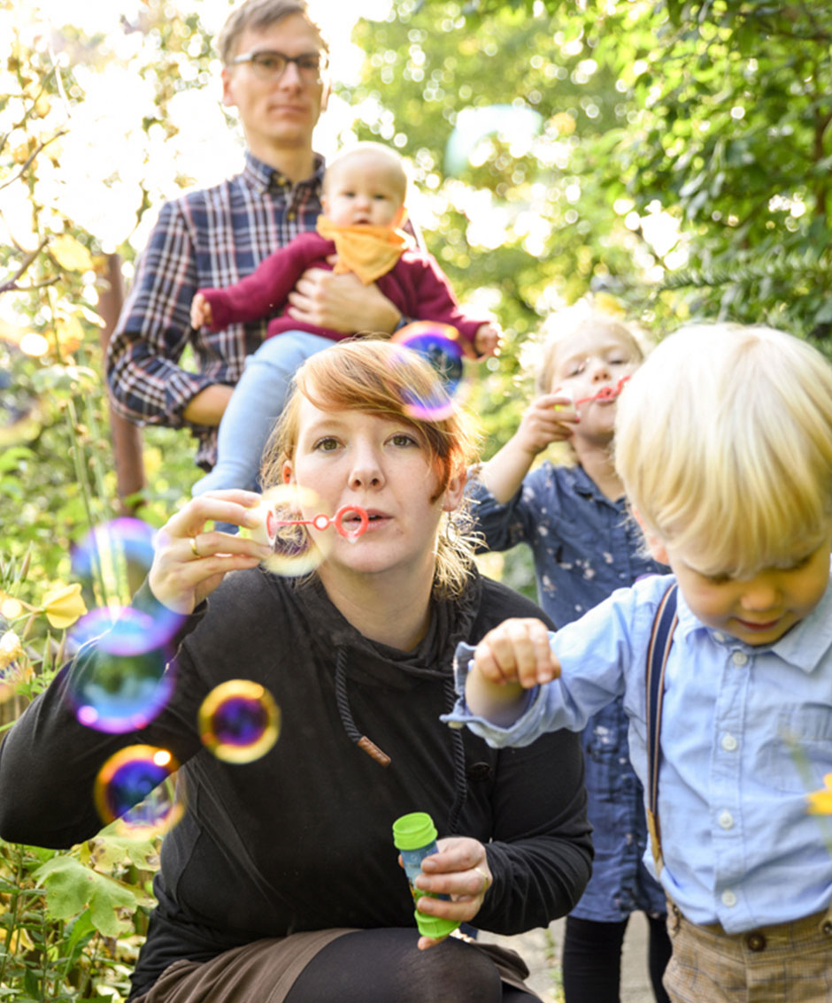 Familienfoto im Garten mit Seifenblasen Sommer, Familienfotograf Berlin