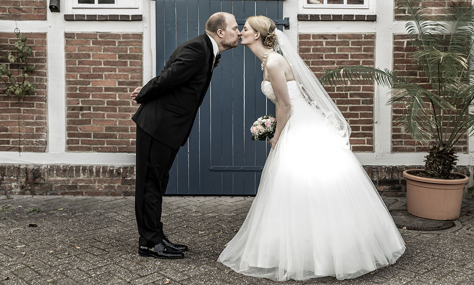 Hochzeitsfoto Brautpaar Kuss vor Scheunentor Schloßgarten Oldenburg